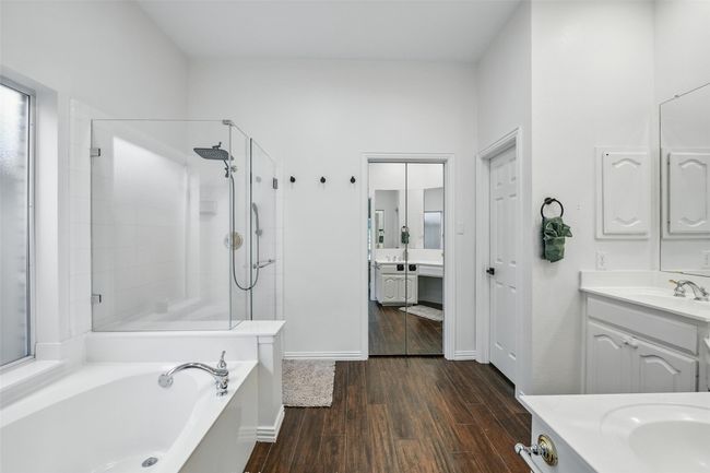 Full bath with two vanities, wood finished floors, a tile shower, and a bath | Image 20