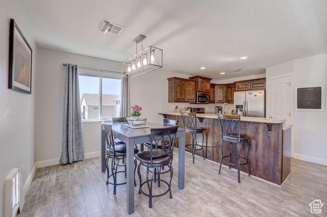 Dining area with baseboards, visible vents, and light wood-style flooring | Image 4