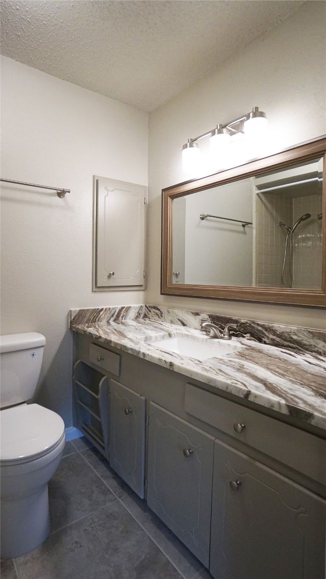 The 2nd bath accommodates bedrooms 2 and 3. It features a lengthy granite-topped vanity, a lovely mirror, nice lighting, and a medicine cabinet. | Image 19