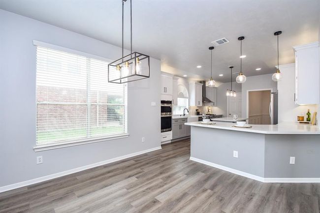 Enjoy an early cup of coffee while basking in the morning light in your 11' x 11' breakfast room framed by a large window with open views to your backyard. It's the perfect spot to start your day with peace, sunlight, and a serene view of nature. | Image 13