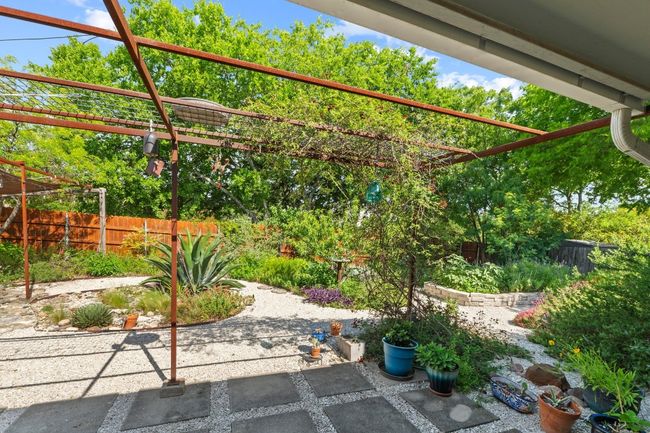 Your living space extends onto the beautifully designed back porch with a trellised pergola overhead. Catch epic sunsets out here in the evening with the backyard facing west. | Image 15
