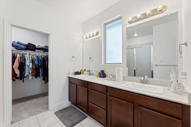 Full ensuite bathroom with double vanity, dual sinks, tile floors, and a spacious closet | Image 24