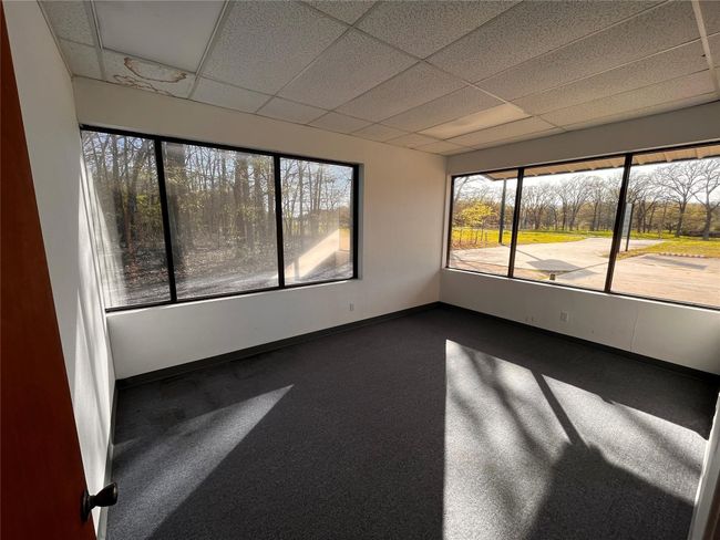 Spare room with dark carpet, baseboards, and a drop ceiling | Image 6