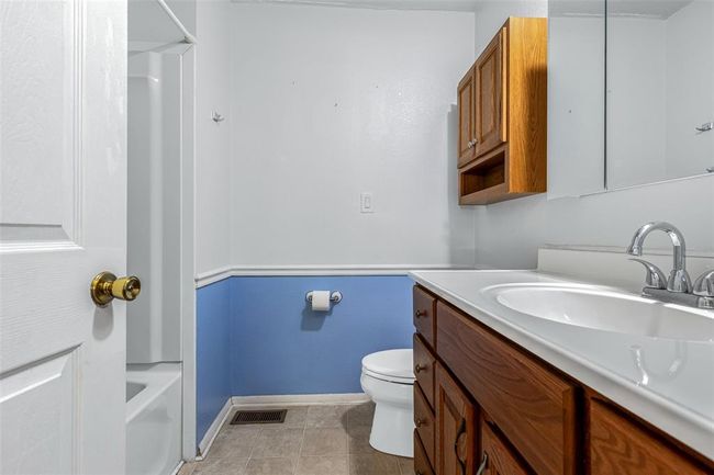 Full bathroom with vanity, toilet, baseboards, tile patterned floors, and bathing tub / shower combination | Image 53