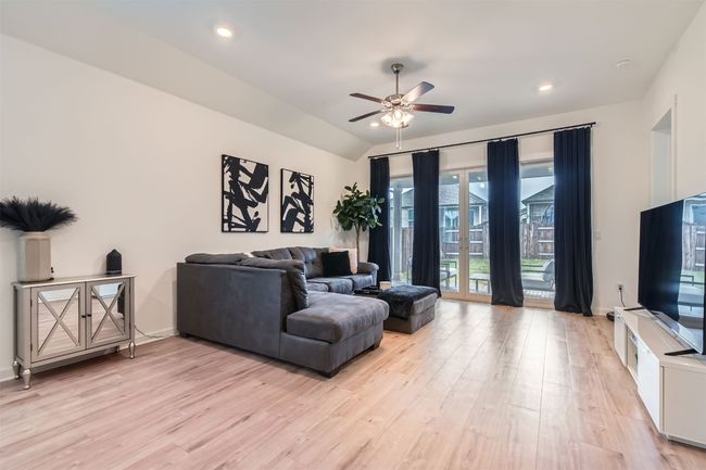 Living area featuring light wood-type flooring, a ceiling fan, recessed lighting, and vaulted ceiling | Image 5