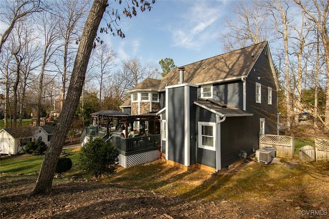 View of side of home featuring a gate, central AC, fence, a gazebo, and a wooden deck | Image 37