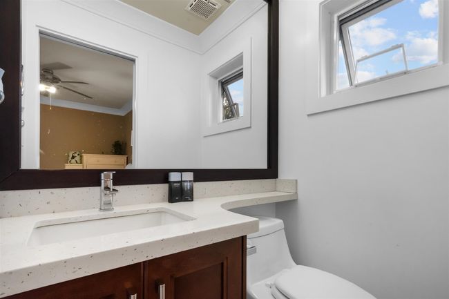 Bathroom with plenty of natural light, toilet, vanity, ceiling fan, and ornamental molding | Image 22