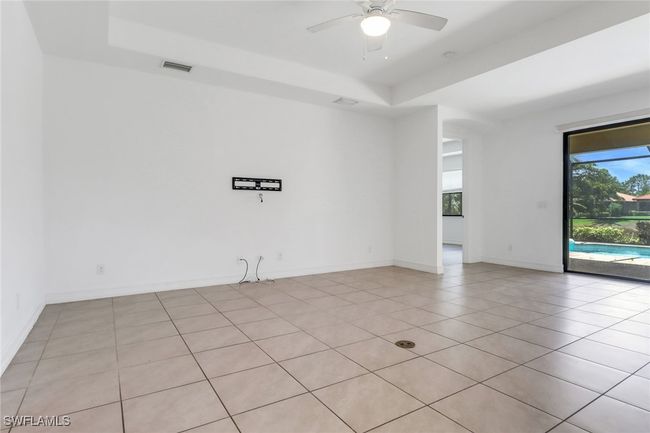 Spare room featuring a raised ceiling, ceiling fan, light tile patterned floors, and baseboards | Image 18