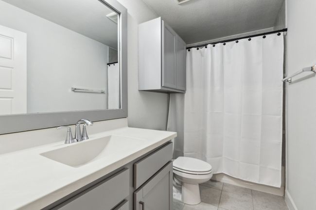 Full bath with tile patterned flooring, toilet, vanity, and curtained shower | Image 25