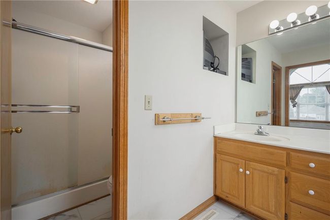 Full bath featuring a stall shower, vanity, toilet, baseboards, and tile patterned flooring | Image 20