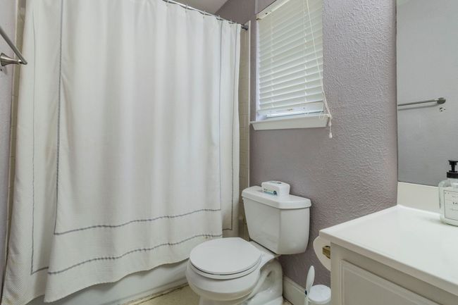 Full bathroom with a textured wall, toilet, and vanity | Image 20