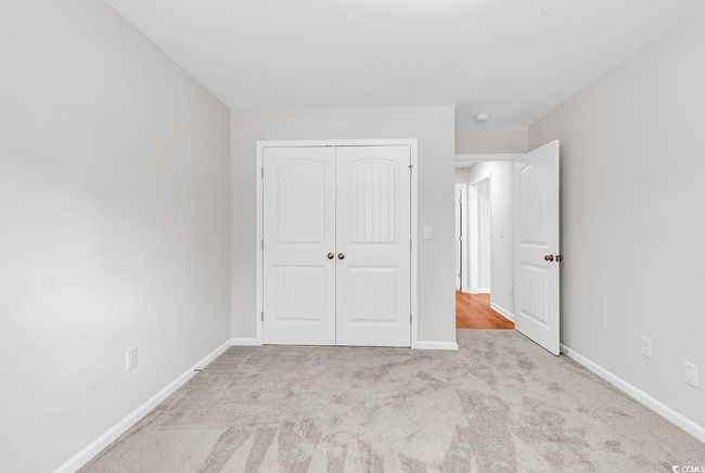 Unfurnished bedroom with carpet floors, a closet, and baseboards | Image 14