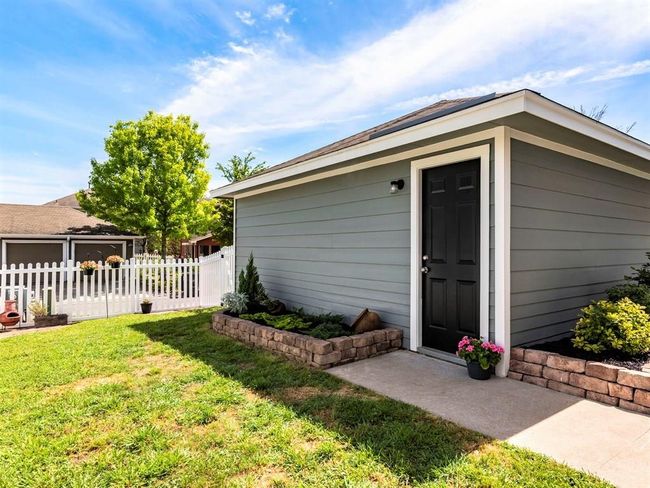 A white picket fence adds to the charm of this vibrant home. | Image 26