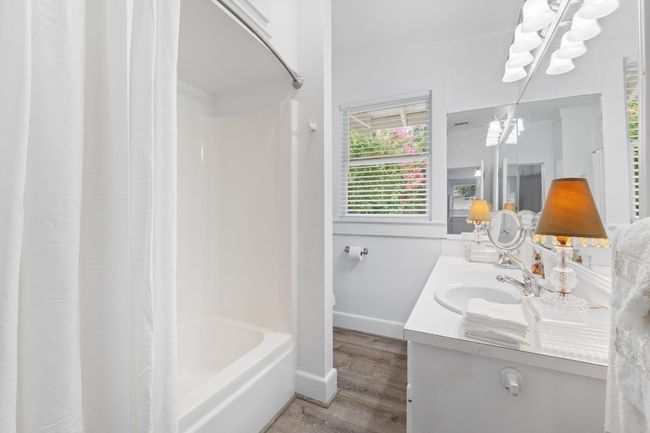 Full bath with wood finished floors, vanity, a chandelier, and shower / bath combination with curtain | Image 14