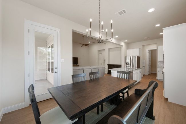 Dining area with light wood-style floors, recessed lighting, a chandelier, and baseboards | Image 10