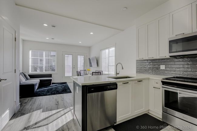 Kitchen with stainless steel appliances, white cabinetry, light countertops, and recessed lighting | Image 27