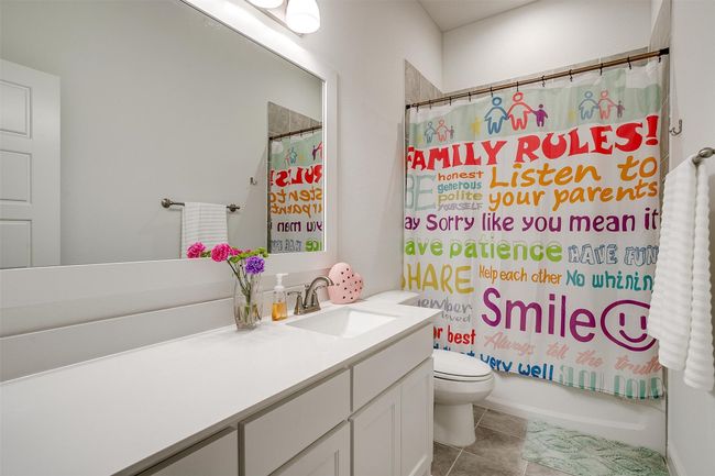 Bathroom featuring toilet, vanity, shower / bathtub combination with curtain, and tile patterned floors | Image 27
