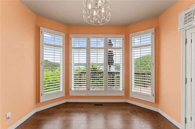 Unfurnished dining area featuring visible vents, a notable chandelier, dark wood finished floors, and baseboards | Image 22