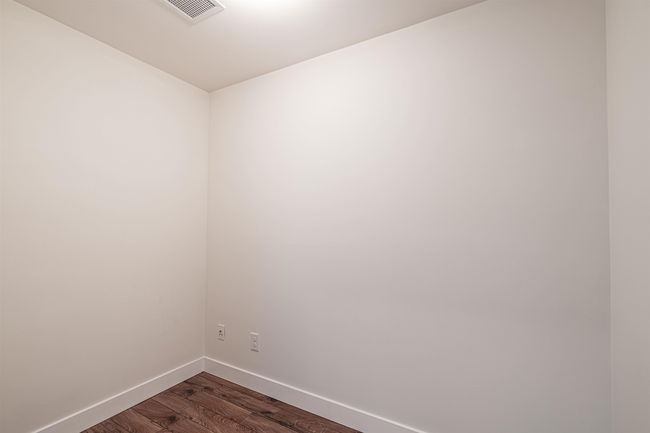 Spare room featuring baseboards and dark wood-type flooring | Image 14