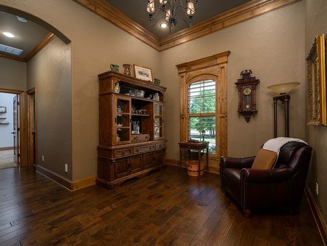 Sitting room featuring dark wood-style flooring, ornamental molding, arched walkways, a notable chandelier, and visible vents | Image 5