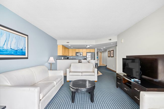 Living area featuring a textured ceiling, carpet floors, and visible vents | Image 10
