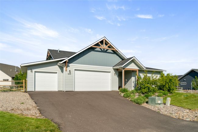 View of front of property with a garage, driveway, board and batten siding, and a shingled roof | Image 45