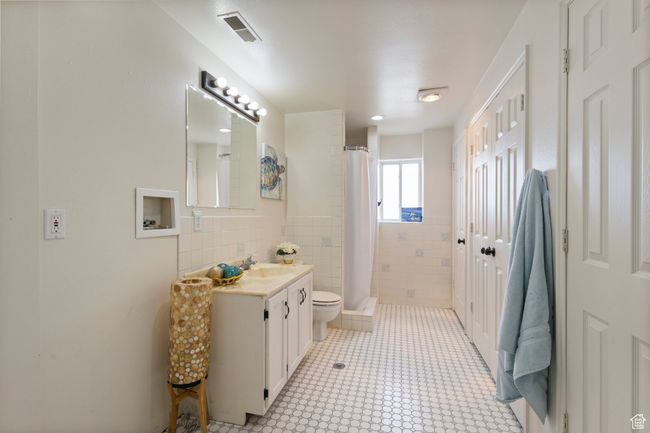 Full bathroom with toilet, vanity, a stall shower, and tile walls & Laundry Hookups | Image 28