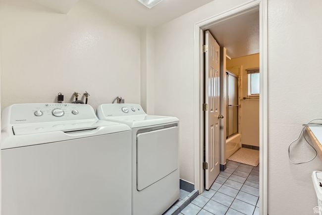 Washroom featuring separate washer and dryer and light tile patterned flooring | Image 26
