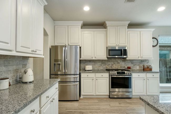 The kitchen features granite countertops, stainless steel appliances, and a gas stove. | Image 6