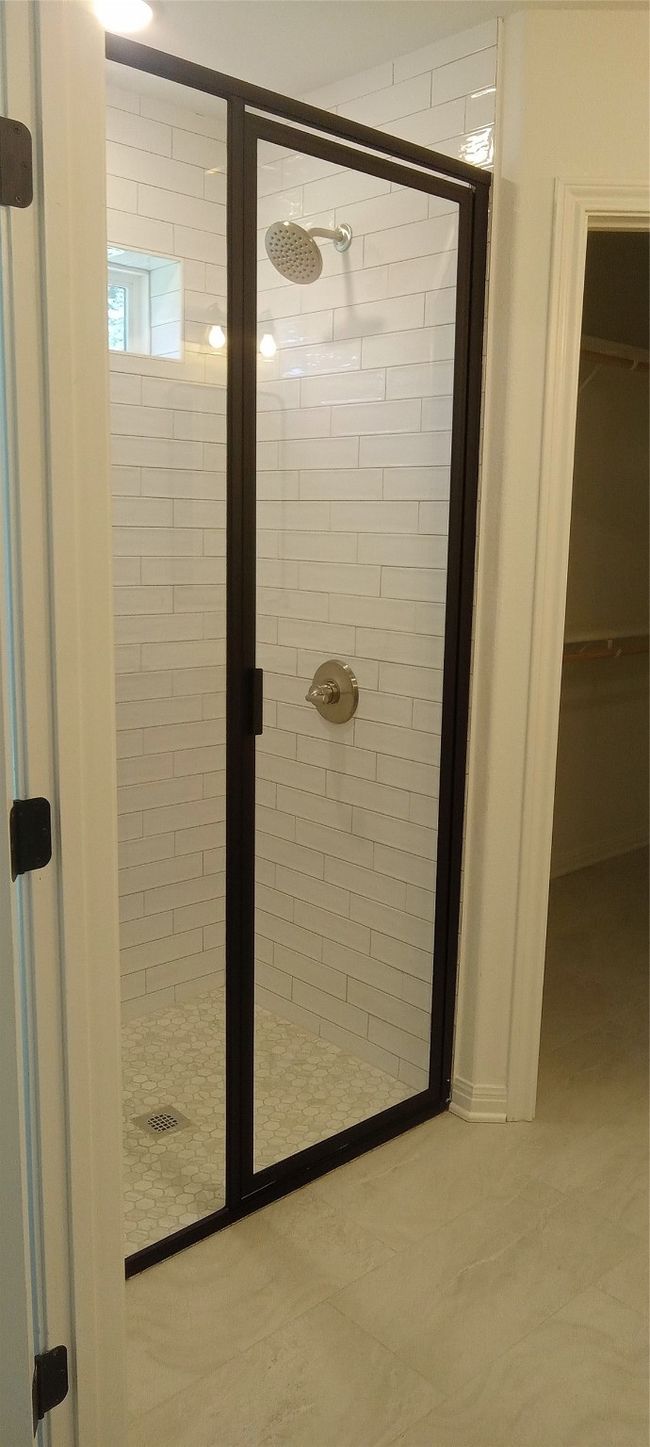 Bathroom featuring a shower stall and a spacious closet | Image 9