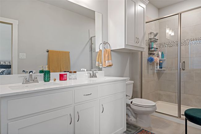 Bathroom with toilet, tile patterned flooring, vanity, and walk in shower | Image 13