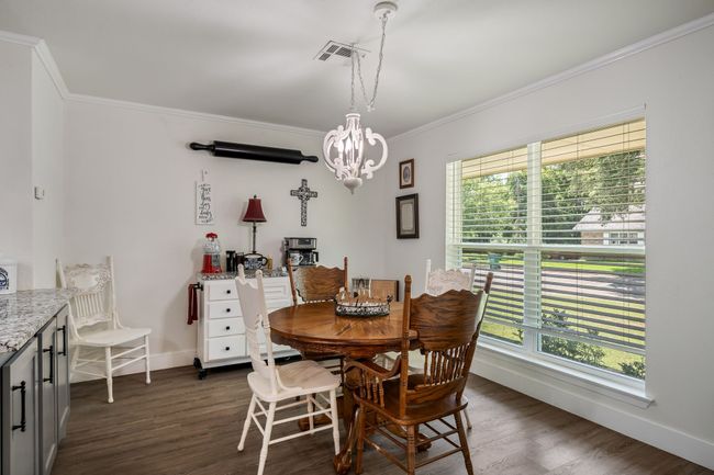 Dining space featuring ornamental molding, plenty of natural light, a chandelier, and dark wood-type flooring | Image 13