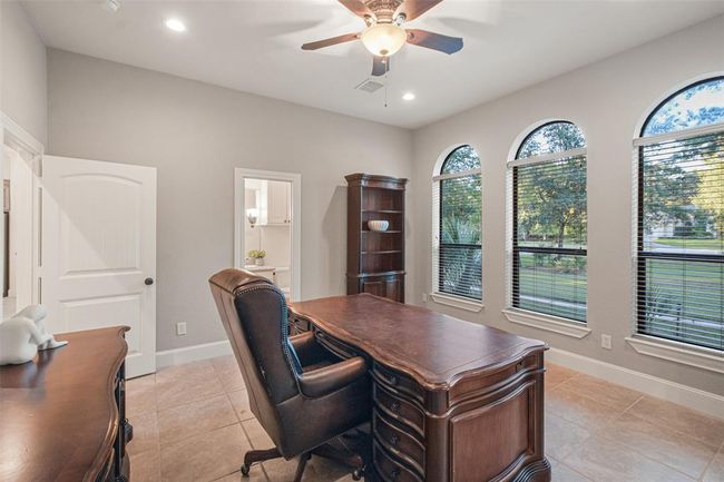 Spacious, well-lit study and large arched windows offering a view of the greenery outside. The office, with its full en-suite bath, can be transformed into a 5th bedroom. | Image 11