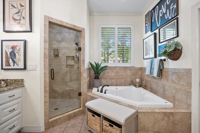 Bathroom featuring independent shower and bath, vanity, tile floors, and crown molding | Image 29