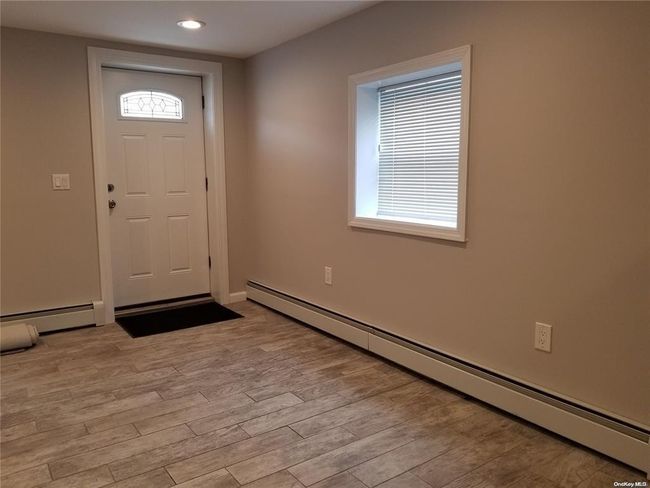 Entrance foyer with a baseboard heating unit, light wood-style floors, recessed lighting, and baseboards | Image 5