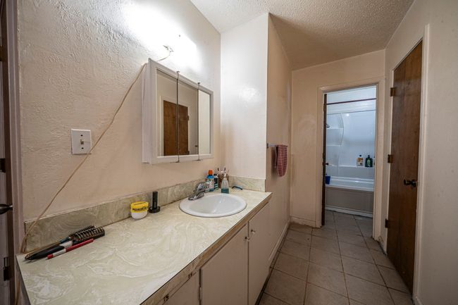 Full bathroom with vanity, tile patterned floors, and a textured ceiling | Image 17
