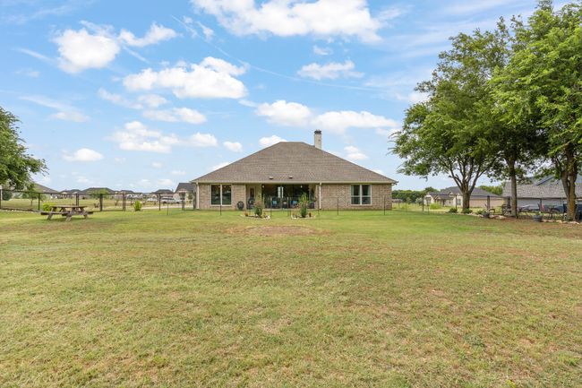 Back of property with a fenced backyard, a chimney, and brick siding | Image 35