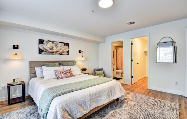 Bedroom featuring visible vents, a walk in closet, connected bathroom, light wood-style floors, and baseboards | Image 14