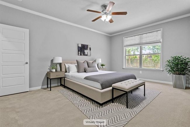 Bedroom with light colored carpet, ornamental molding, baseboards, and a ceiling fan | Image 7