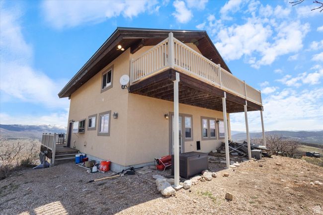Rear view of house featuring a deck with mountain view and stucco siding | Image 23