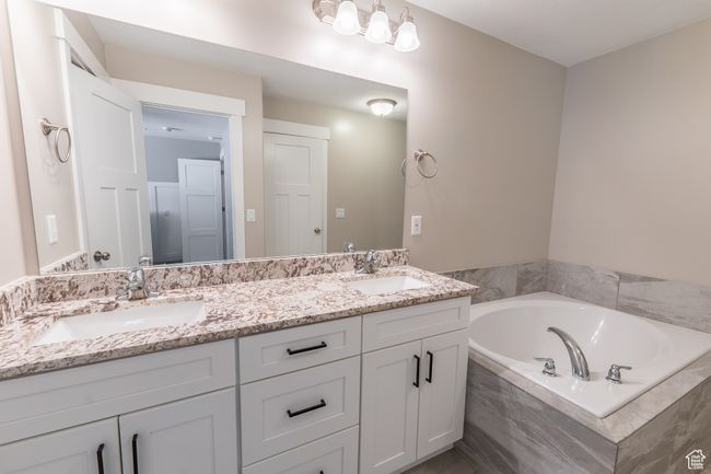 Full bathroom featuring double vanity and a garden tub | Image 10