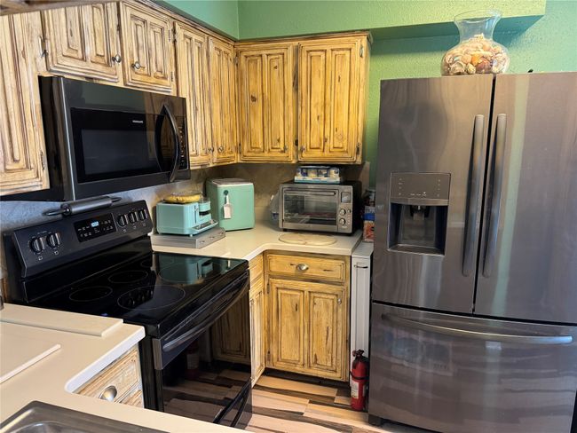Kitchen with stainless steel appliances, light countertops, and light wood finished floors | Image 5