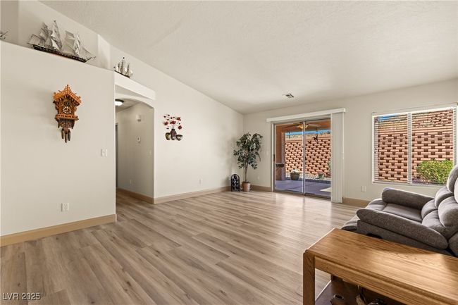 Living room featuring vaulted ceiling, light wood-style floors, arched walkways, and a textured ceiling | Image 19