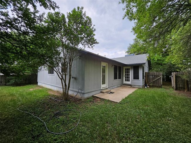 Rear view of house featuring a shingled roof, a yard, a fenced backyard, and a patio | Image 33
