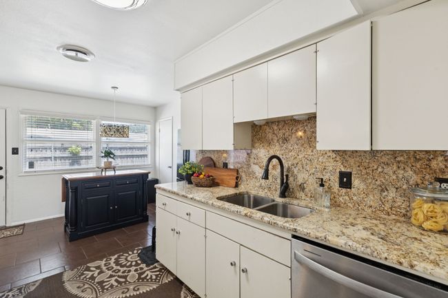 Kitchen with dishwasher, white cabinetry, decorative backsplash, and light stone counters | Image 7