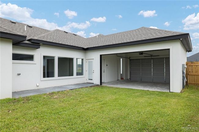 Back of property with roof with shingles, stucco siding, and a garage | Image 17