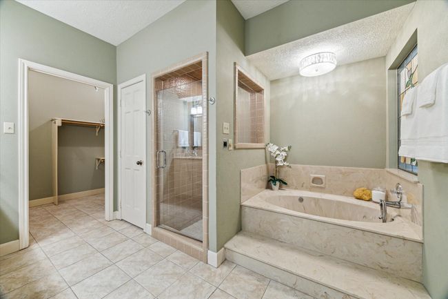 The generous 11’x11’ primary bath has a jetted tub and separate walk-in shower. | Image 20