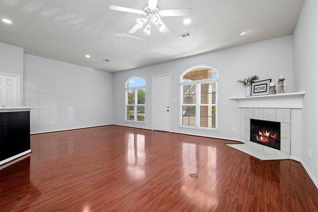Step into this stunning open concept living space, where the living, dining and kitchen areas flow together seamlessly. The hardwood flooring, oversized windows and fireplace are the perfect touch. | Image 6