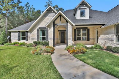 This former model home boasts a stunning brick and stone exterior, enhanced by charming wood beam accents. | Image 3