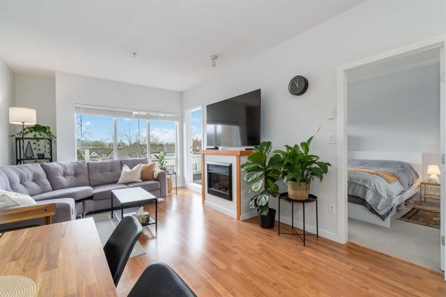 Living area featuring baseboards, wood finished floors, and a glass covered fireplace | Image 11